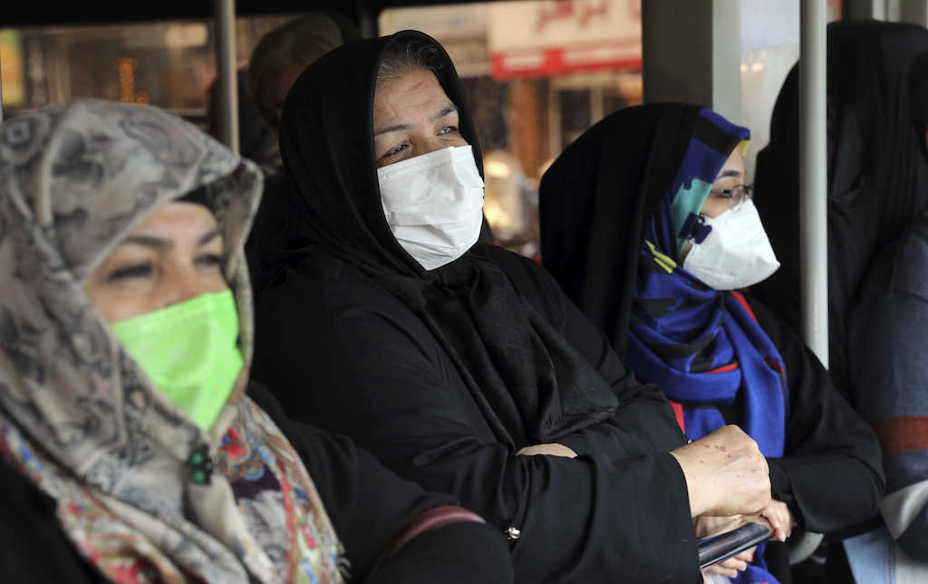 Donne arabe in autobus con velo e mascherina